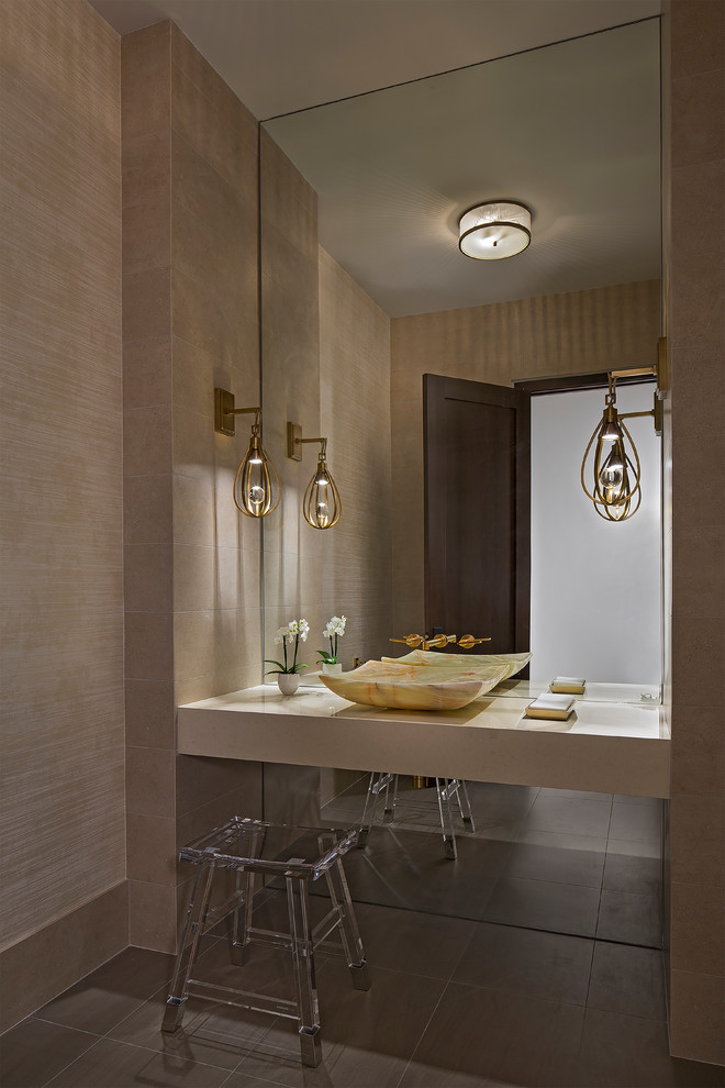 Mid-sized contemporary powder room in Detroit with louvered cabinets, a wall-mount toilet, beige tile, ceramic tile, beige walls, porcelain floors, a vessel sink, engineered quartz benchtops and grey floor.