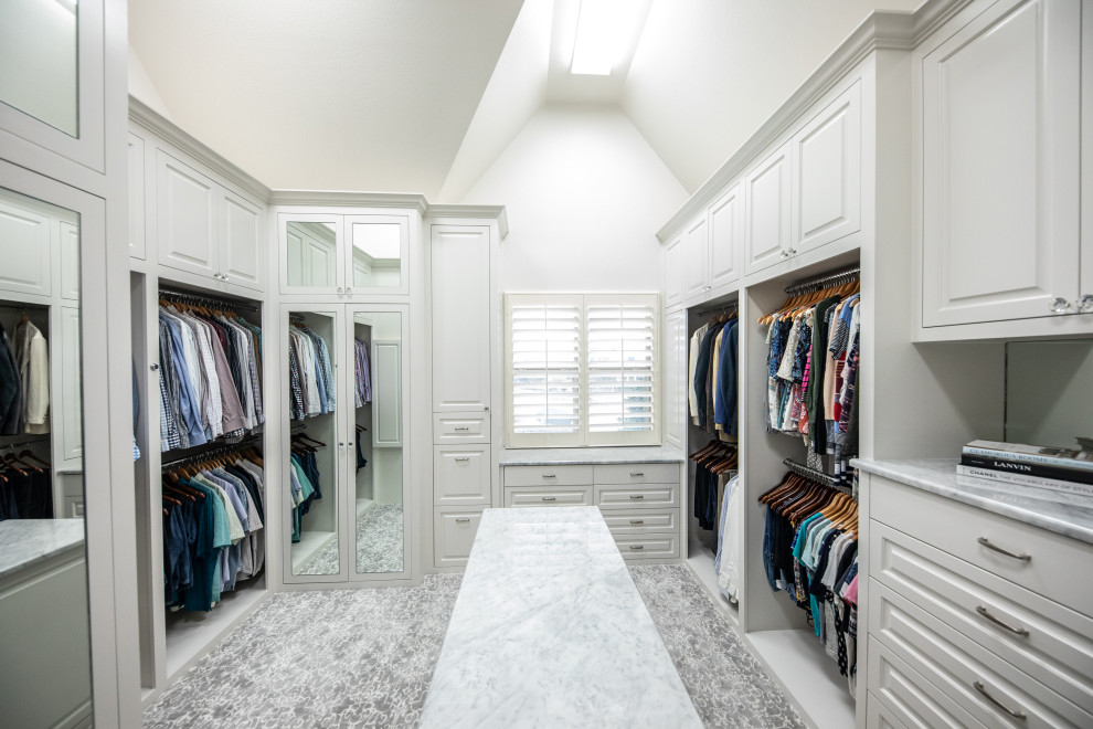 Diseño de armario vestidor unisex y abovedado clásico grande con armarios con rebordes decorativos, puertas de armario blancas, moqueta y suelo gris