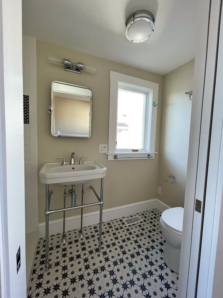 Photo of a small beach style 3/4 bathroom in Providence with an alcove shower, a two-piece toilet, white tile, subway tile, beige walls, a pedestal sink, a sliding shower screen and a single vanity.