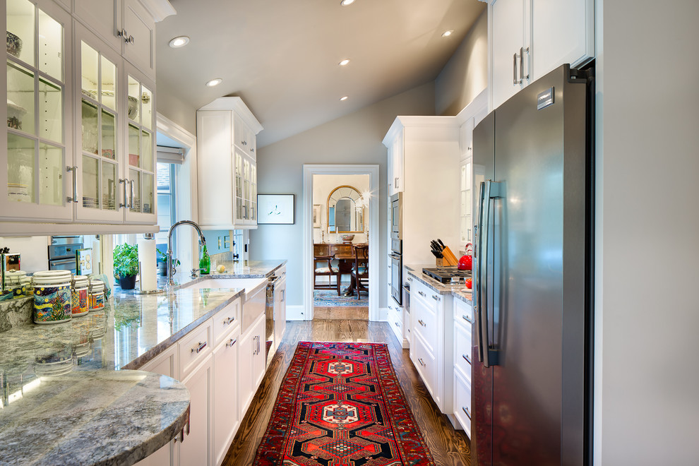 Inspiration for a mid-sized traditional galley separate kitchen in Charlotte with a farmhouse sink, recessed-panel cabinets, white cabinets, granite benchtops, stainless steel appliances, dark hardwood floors, no island and brown floor.