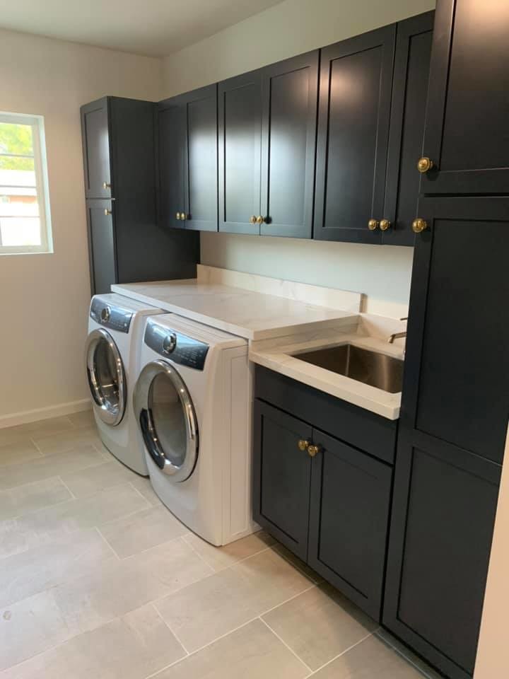 This is an example of a mid-sized contemporary galley utility room in Phoenix with an undermount sink, shaker cabinets, black cabinets, quartzite benchtops, grey walls, porcelain floors, a side-by-side washer and dryer, grey floor and white benchtop.