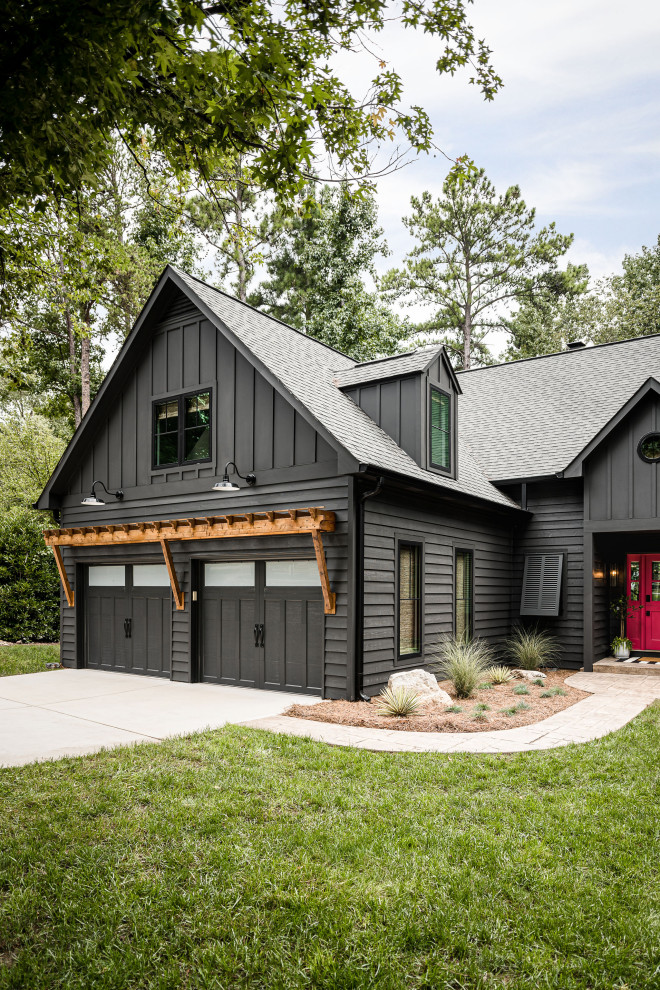 Inspiration for a mid-sized beach style two-storey black house exterior in Charlotte with a gable roof, a shingle roof, a grey roof, board and batten siding and mixed siding.