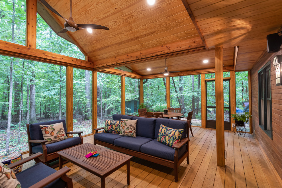 Inspiration for a large rustic screened-in back porch remodel in Raleigh with decking and a roof extension
