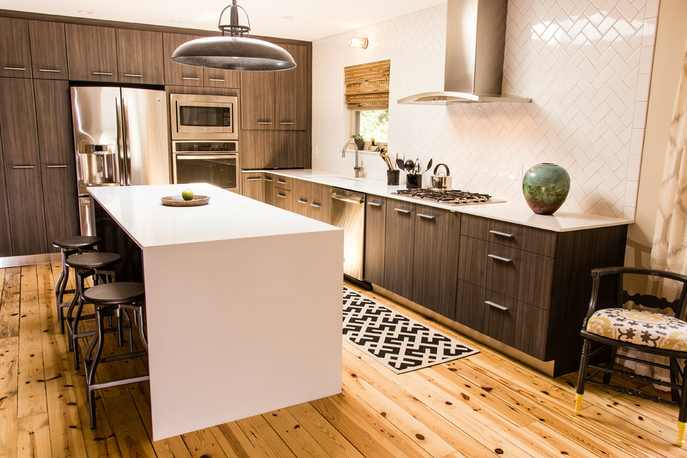 Eat-in kitchen - mid-sized transitional l-shaped medium tone wood floor eat-in kitchen idea with quartz countertops, an undermount sink, flat-panel cabinets, dark wood cabinets, white backsplash, ceramic backsplash, stainless steel appliances and an island