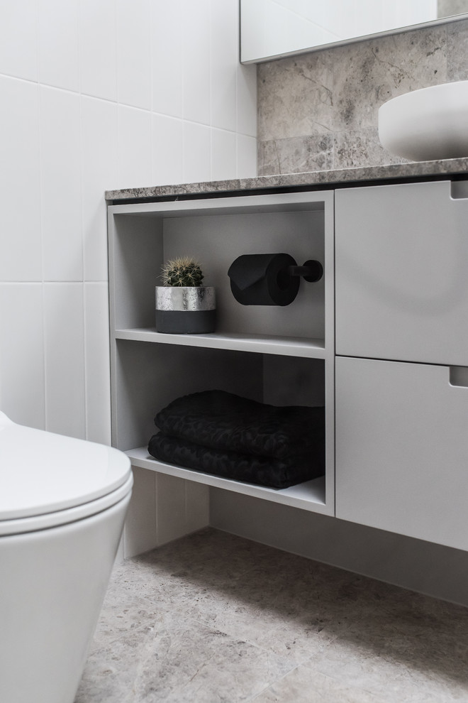 Inspiration for a large contemporary 3/4 bathroom in Melbourne with flat-panel cabinets, grey cabinets, an open shower, a two-piece toilet, multi-coloured tile, porcelain tile, multi-coloured walls, porcelain floors, a vessel sink, limestone benchtops and multi-coloured floor.