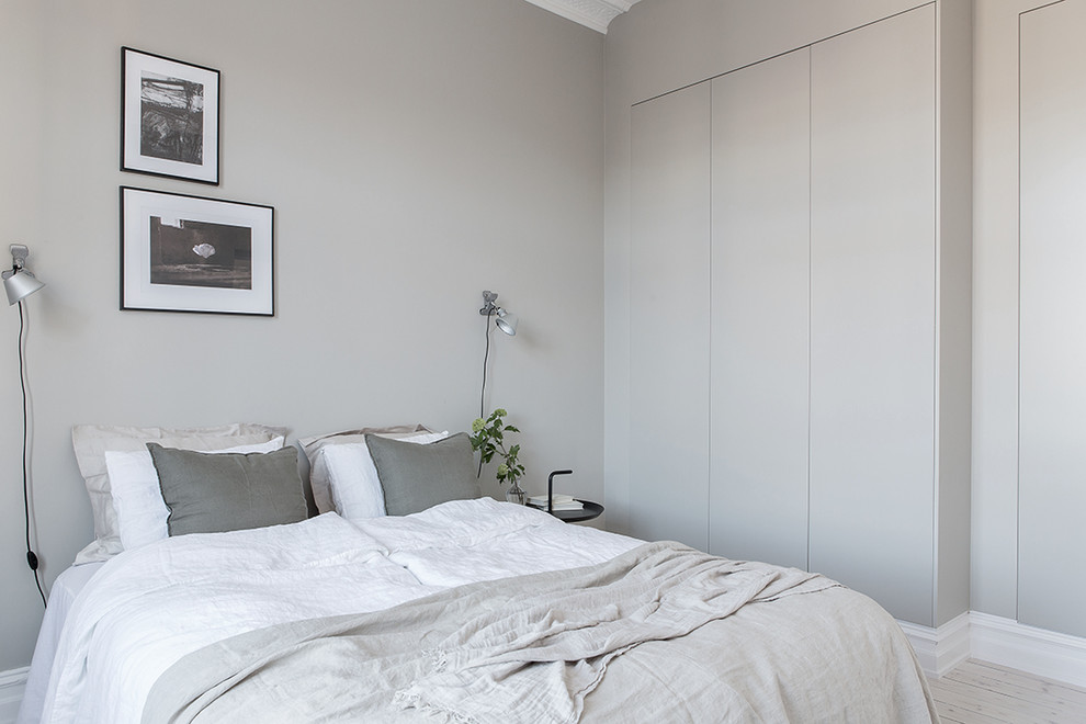 Photo of a traditional bedroom in Gothenburg with grey walls and light hardwood floors.