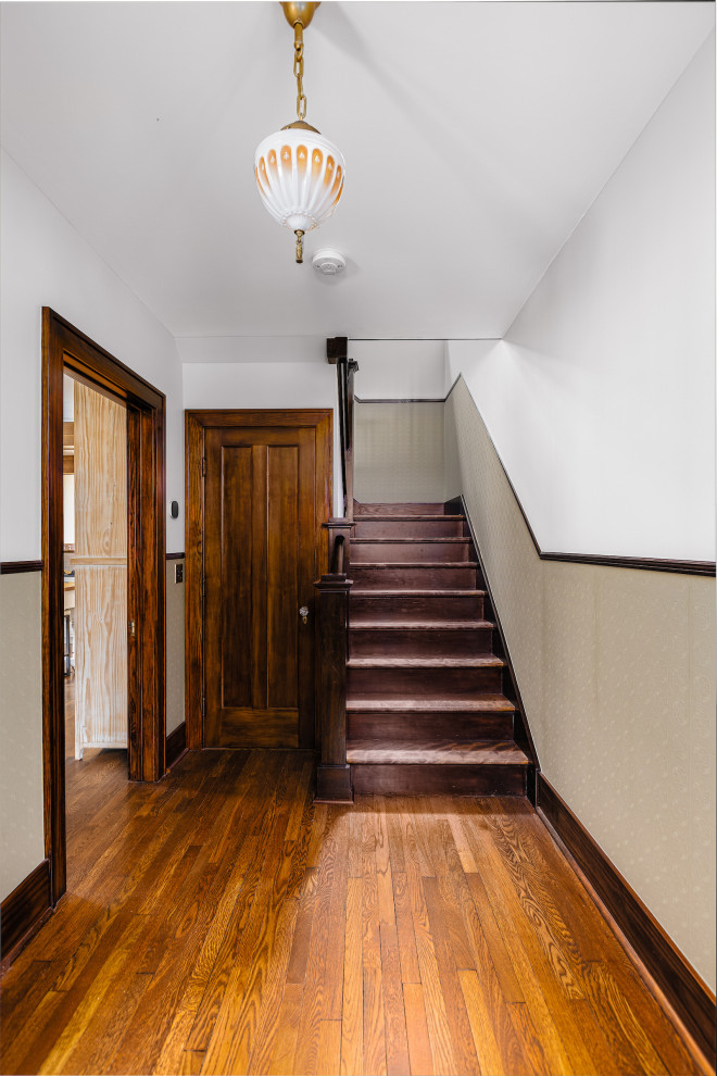 This is an example of a traditional entryway in Detroit with green walls, medium hardwood floors, black floor, vaulted and wallpaper.
