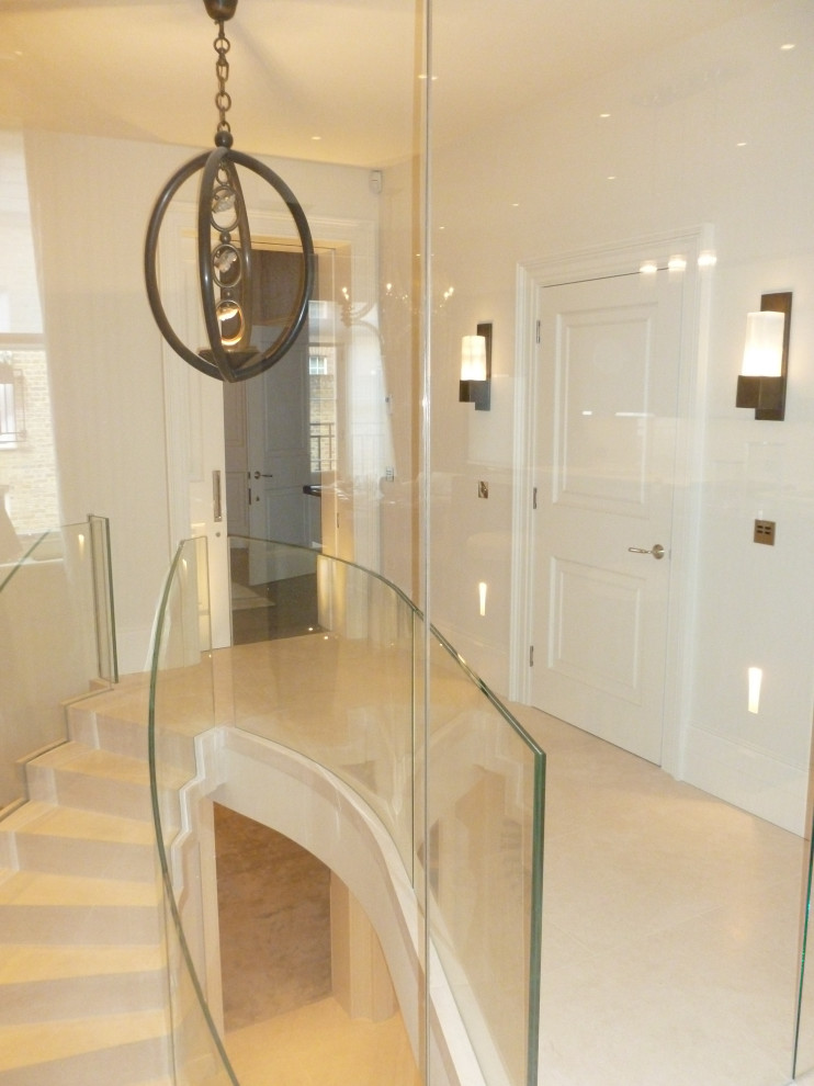 Contemporary limestone floating staircase in Other with limestone risers and glass railing.