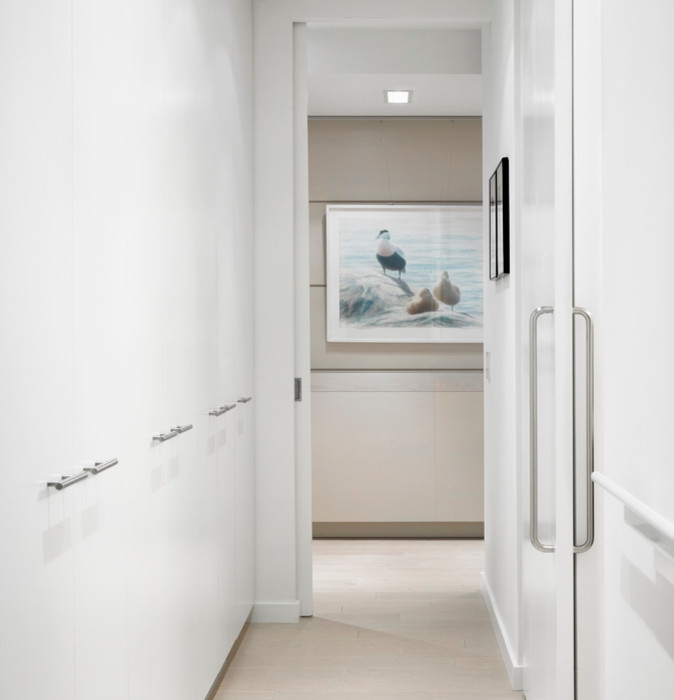 Photo of a contemporary hallway in Toronto with white walls and beige floor.