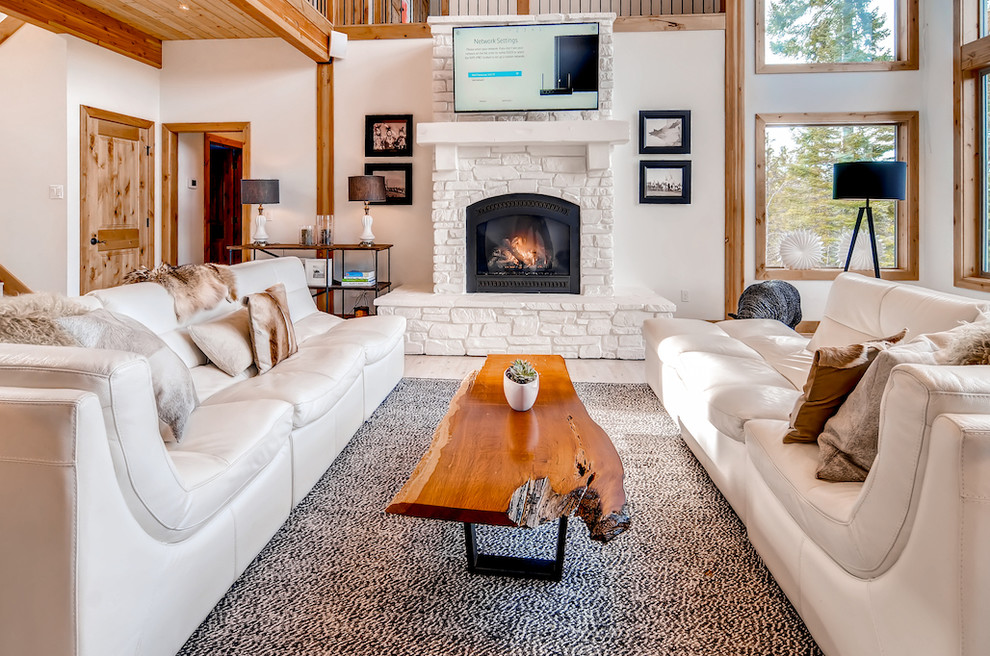 This is an example of a transitional open concept living room in Seattle with white walls, light hardwood floors, a standard fireplace, a metal fireplace surround, a wall-mounted tv and beige floor.