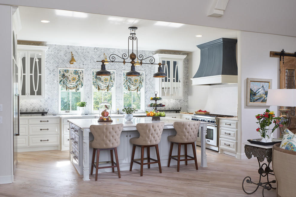 Design ideas for a large traditional u-shaped kitchen in Oklahoma City with raised-panel cabinets, white cabinets, grey splashback, stainless steel appliances, light hardwood floors and with island.
