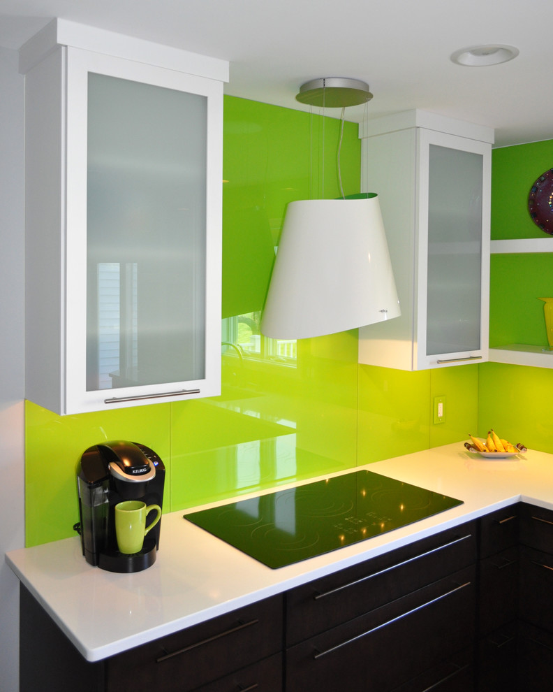 This is an example of a modern u-shaped eat-in kitchen in Other with an undermount sink, flat-panel cabinets, dark wood cabinets, quartz benchtops, green splashback, glass sheet splashback, black appliances, bamboo floors and with island.