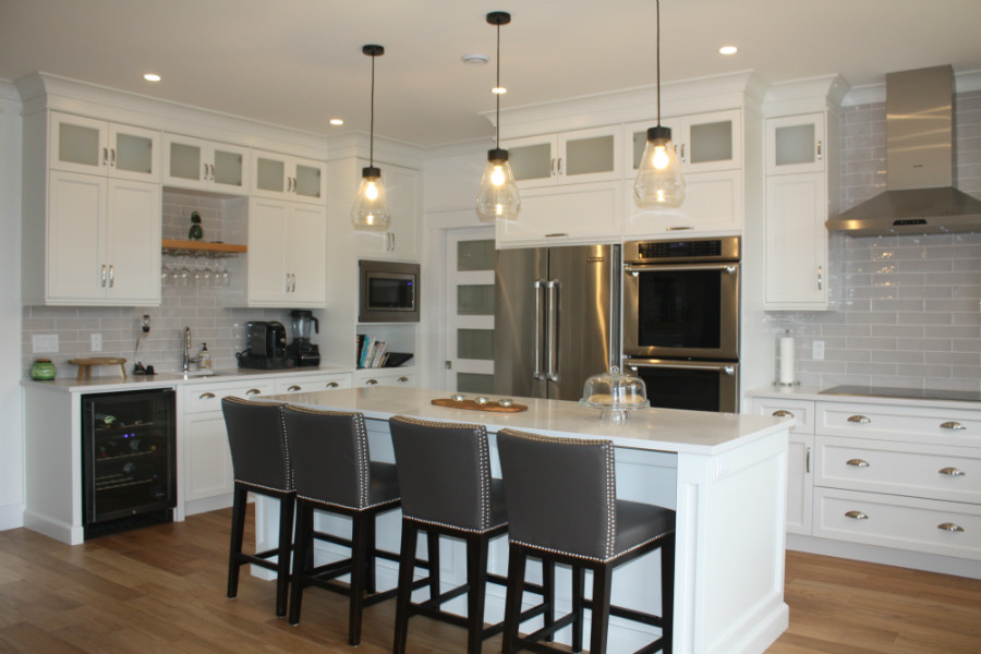 Kitchen pantry - mid-sized transitional l-shaped medium tone wood floor kitchen pantry idea with an undermount sink, shaker cabinets, white cabinets, quartz countertops, gray backsplash, cement tile backsplash, stainless steel appliances, an island and white countertops