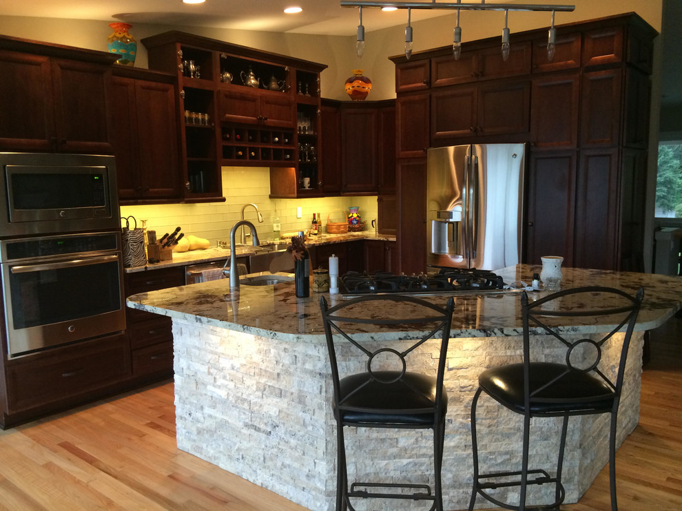 Eat-in kitchen - mid-sized l-shaped eat-in kitchen idea in Seattle with raised-panel cabinets, dark wood cabinets and an island