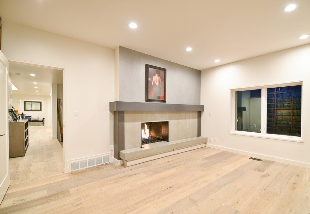 This is an example of a mid-sized transitional study room in Salt Lake City with white walls, light hardwood floors, a standard fireplace, a tile fireplace surround and brown floor.