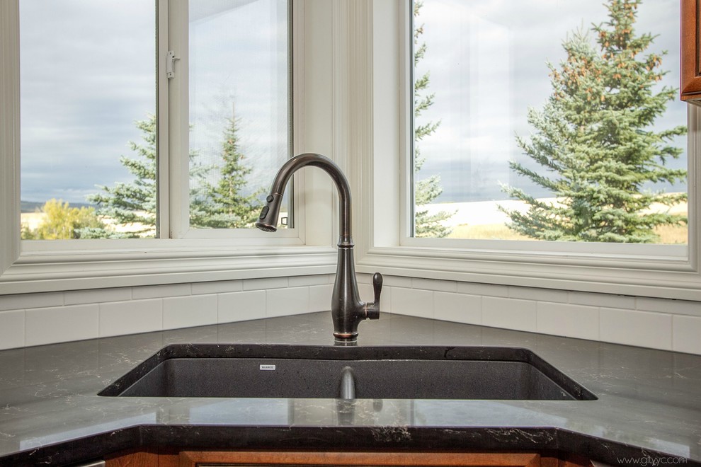 Home design - mid-sized rustic l-shaped laminate floor and black floor home design idea in Calgary with a drop-in sink, raised-panel cabinets, medium tone wood cabinets, quartzite countertops, white backsplash, ceramic backsplash, stainless steel appliances and an island