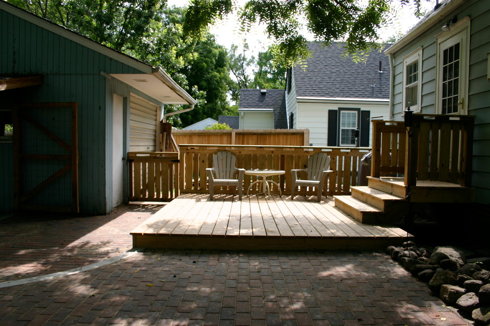 Example of a mid-sized transitional backyard deck design with no cover