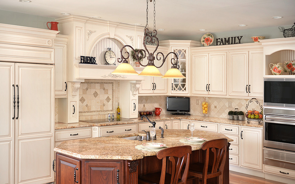 This is an example of a large traditional l-shaped eat-in kitchen in Atlanta with an undermount sink, raised-panel cabinets, white cabinets, granite benchtops, beige splashback, stone tile splashback, stainless steel appliances, medium hardwood floors and with island.