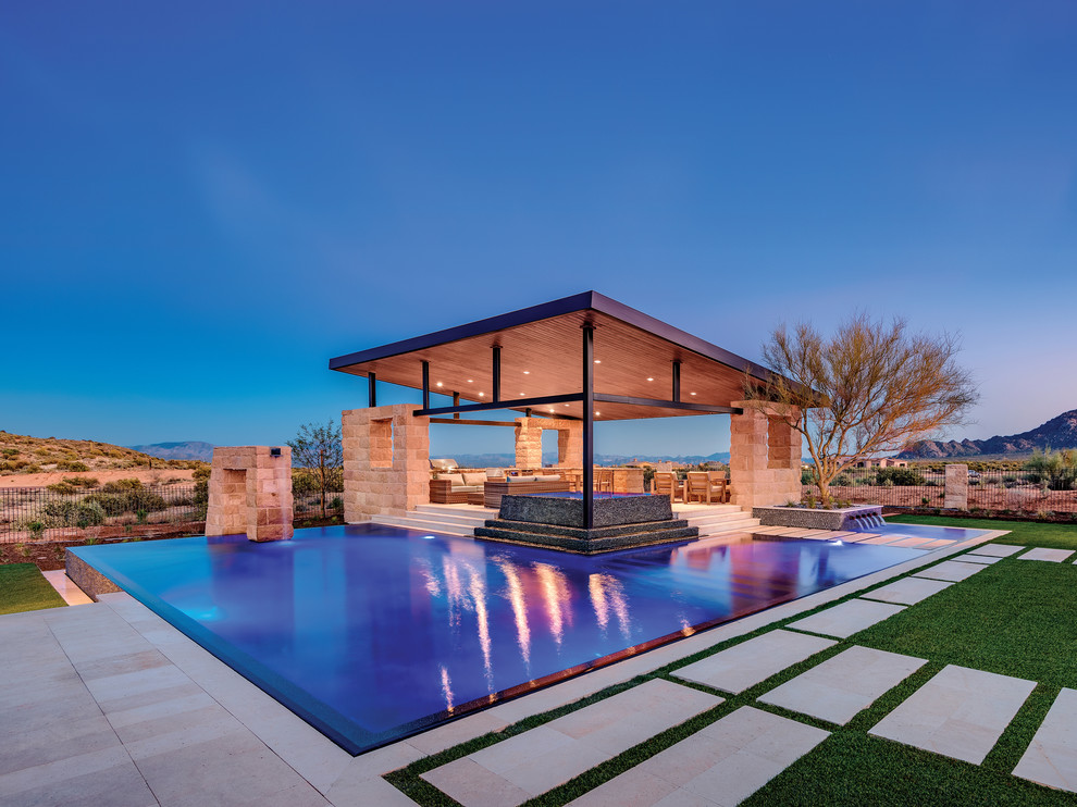 Large contemporary infinity pool in Phoenix with a water feature.