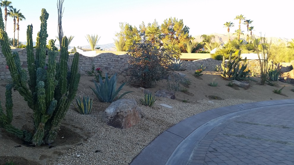 Photo of a large front yard full sun driveway in Other with a garden path and natural stone pavers.
