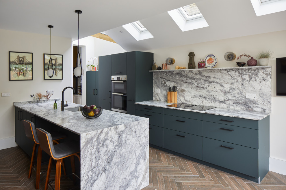 Inspiration for a medium sized contemporary galley open plan kitchen in London with a submerged sink, flat-panel cabinets, green cabinets, engineered stone countertops, engineered quartz splashback, black appliances and an island.