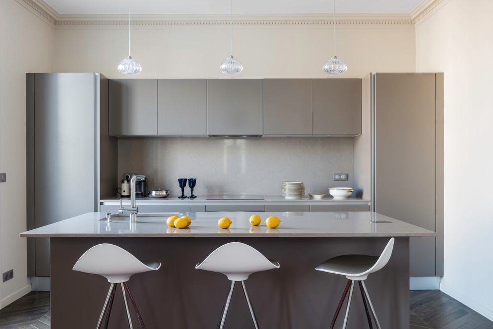 Design ideas for a small contemporary galley eat-in kitchen in Nice with an undermount sink, flat-panel cabinets, grey cabinets, grey splashback, dark hardwood floors, with island and stainless steel benchtops.