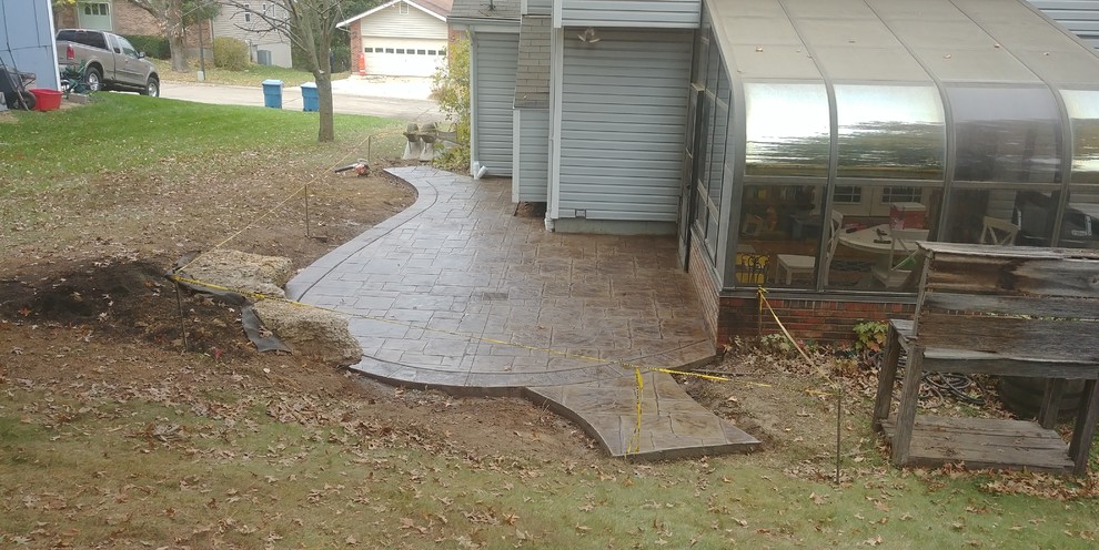 Stamped Concrete Patio with limestone boulder sitting wall in St Charles Missou