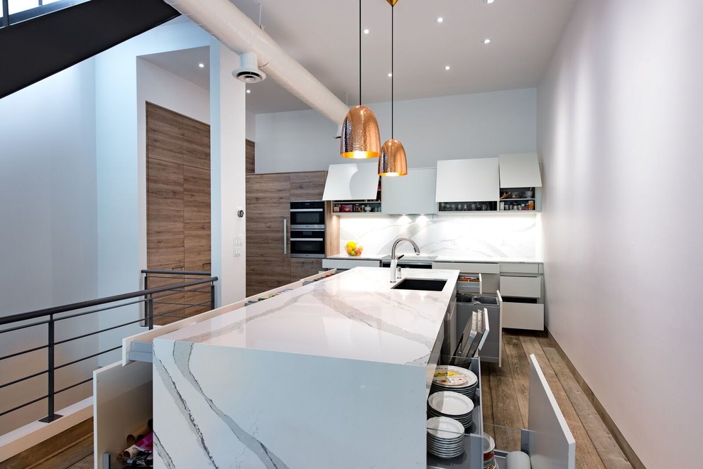 Design ideas for a contemporary l-shaped eat-in kitchen in Toronto with an undermount sink, flat-panel cabinets, white cabinets, white splashback, panelled appliances, medium hardwood floors, with island and brown floor.