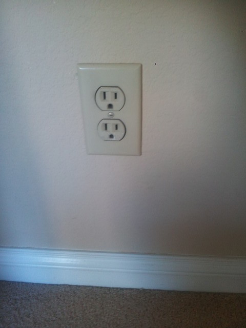 White electrical switches on almond painted walls