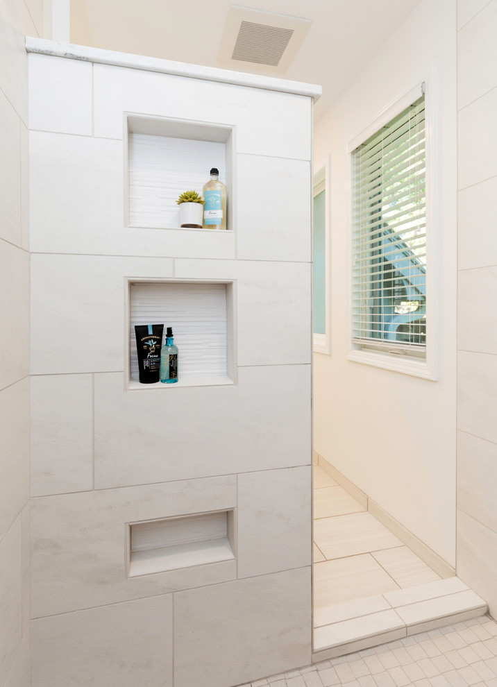 Doorless shower - mid-sized transitional master ceramic tile and gray floor doorless shower idea with recessed-panel cabinets, white cabinets, a two-piece toilet, white walls, an undermount sink, quartz countertops and white countertops