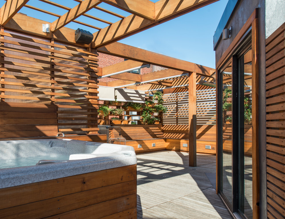 Small modern rooftop deck in DC Metro with an outdoor kitchen and a pergola.