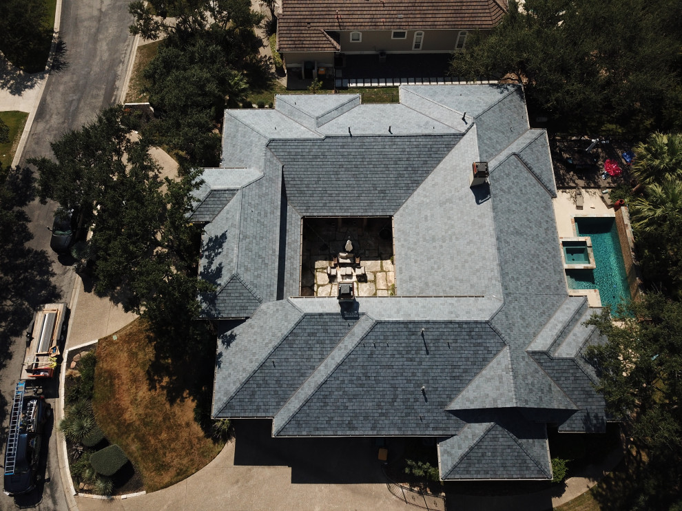 Design ideas for a one-storey house exterior in Austin with a tile roof and a grey roof.