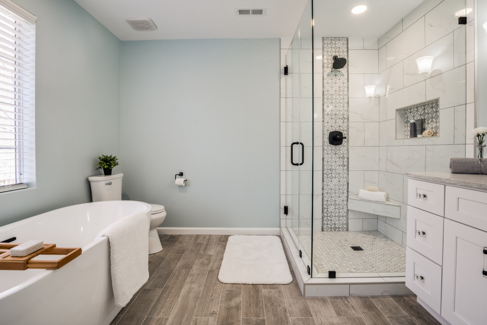 Inspiration for a traditional master bathroom in Charlotte with shaker cabinets, white cabinets, a freestanding tub, a corner shower, a two-piece toilet, white tile, marble, grey walls, an undermount sink, brown floor, a hinged shower door, beige benchtops, a niche, a single vanity and a built-in vanity.