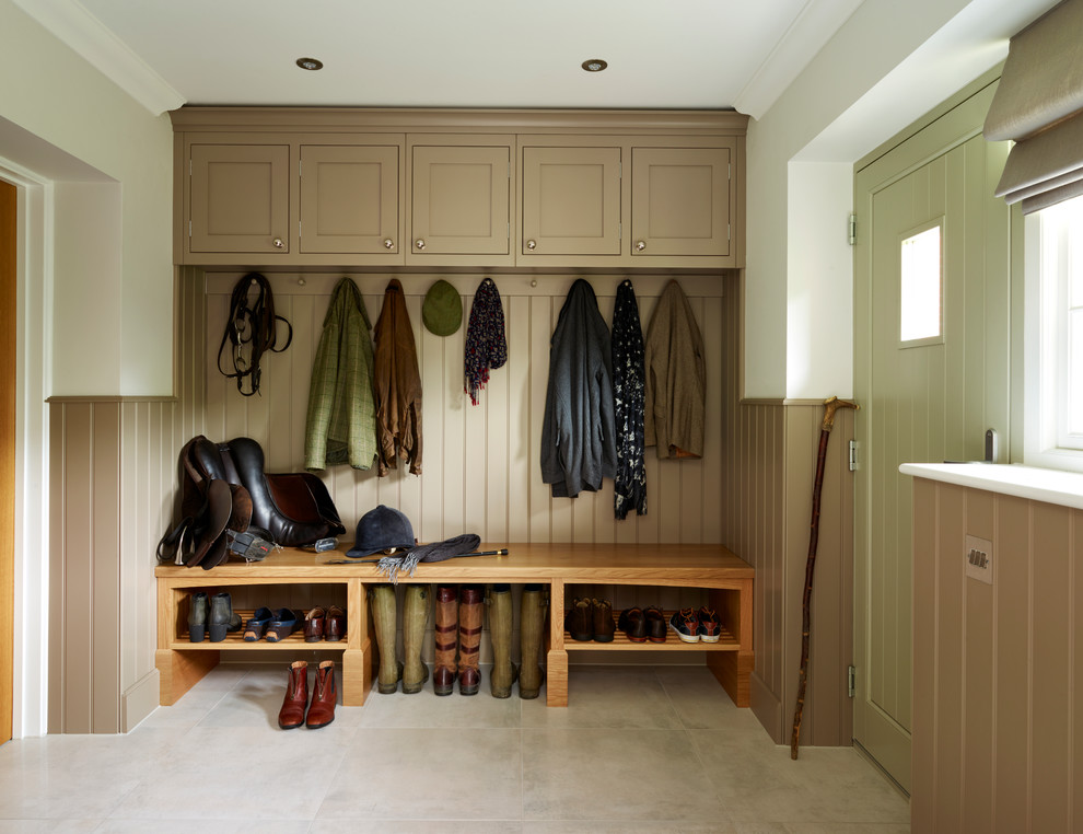 This is an example of a mid-sized country mudroom in Essex with brown walls and a green front door.