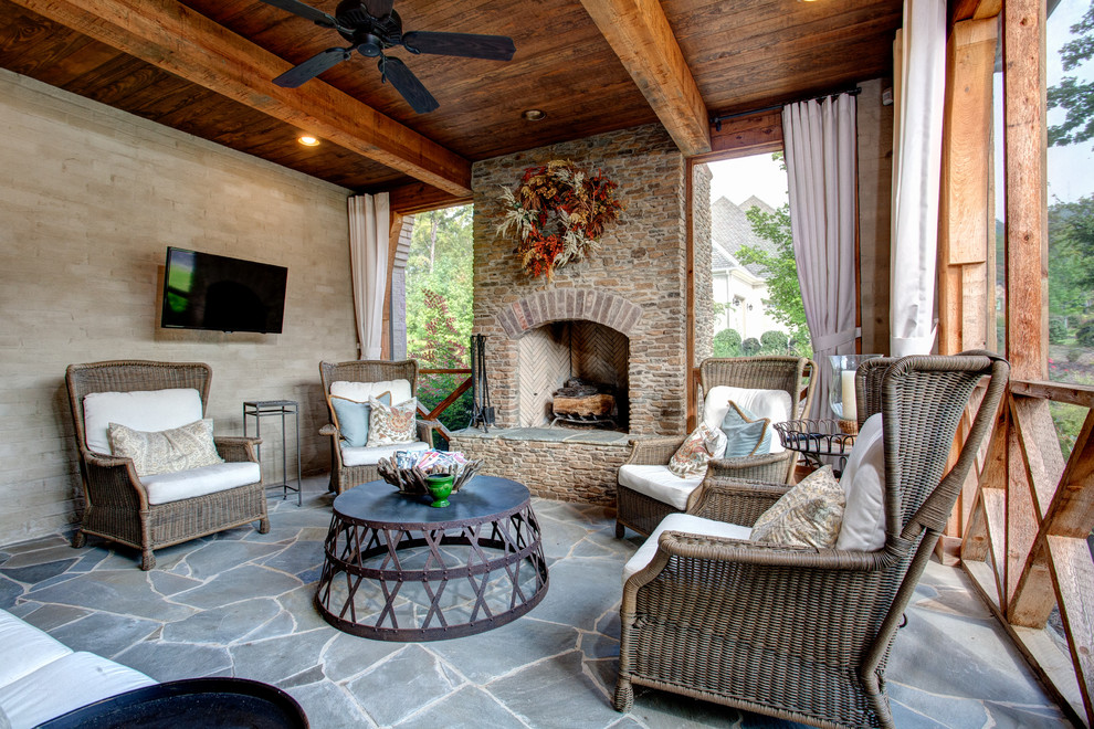 Mid-sized traditional backyard verandah in Little Rock with a fire feature, a roof extension and natural stone pavers.