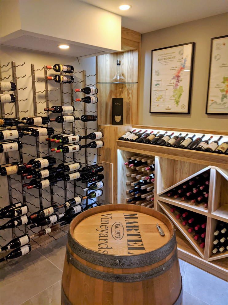 This is an example of a medium sized contemporary wine cellar in Montreal with porcelain flooring, display racks and grey floors.