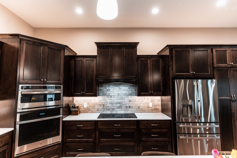 Example of a huge classic u-shaped medium tone wood floor and multicolored floor open concept kitchen design in Other with an undermount sink, flat-panel cabinets, dark wood cabinets, quartz countertops, multicolored backsplash, porcelain backsplash, stainless steel appliances, an island and white countertops