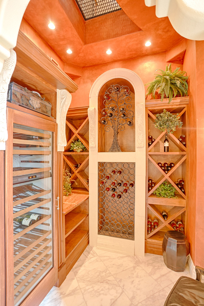 Mid-sized mediterranean wine cellar in Orlando with marble floors, diamond bins and white floor.