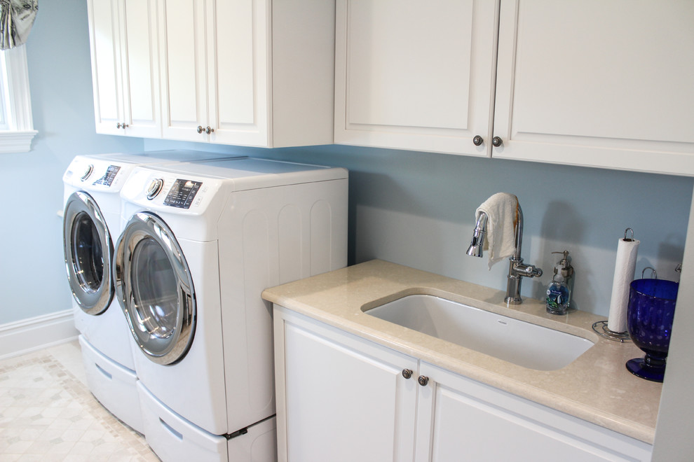 Design ideas for a large traditional galley utility room in New York with a drop-in sink, white cabinets, blue walls, ceramic floors, a side-by-side washer and dryer and raised-panel cabinets.