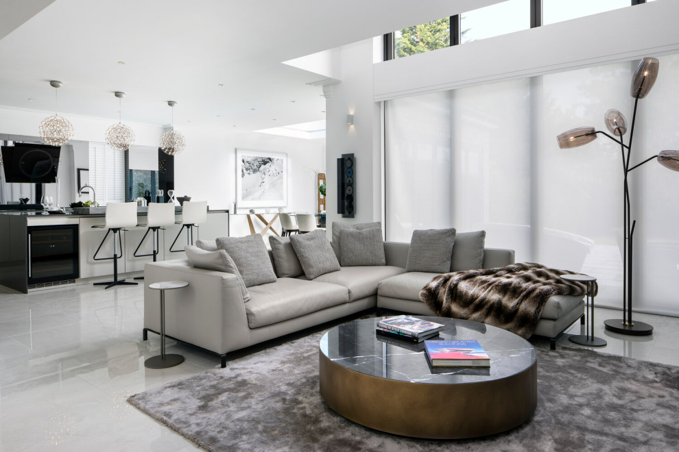 Cette image montre un salon design ouvert avec un mur blanc et un sol gris.
