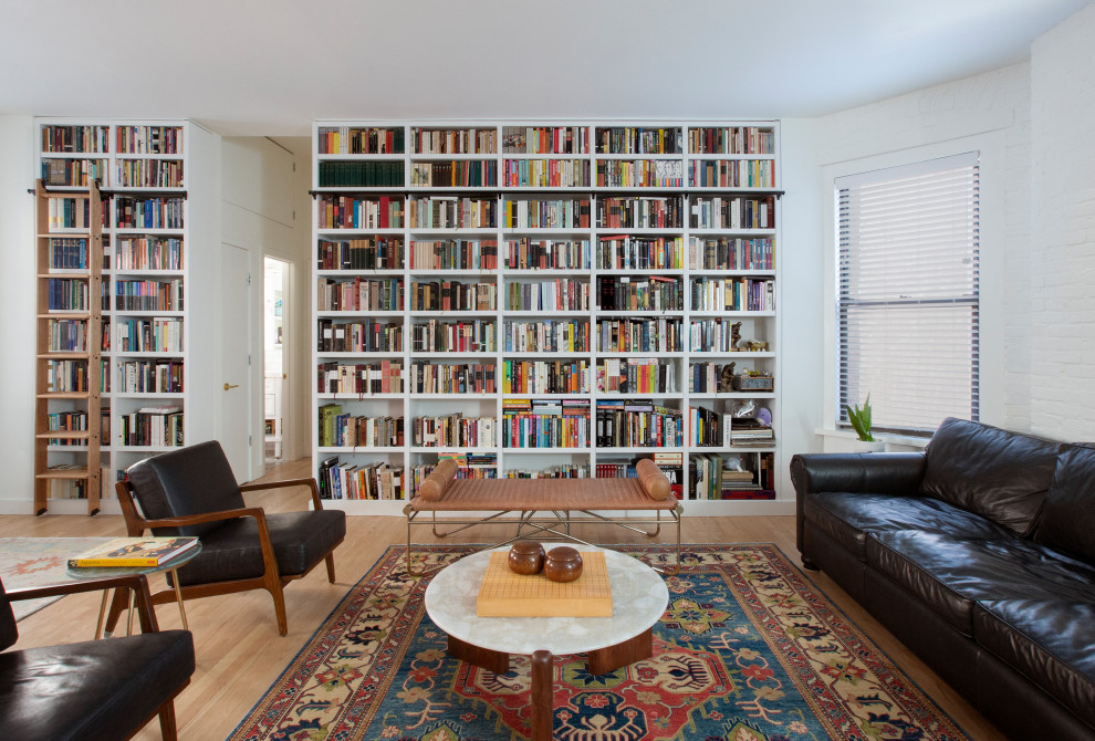 Design ideas for a mid-sized contemporary open concept living room in New York with a library, white walls, light hardwood floors, no tv and brown floor.