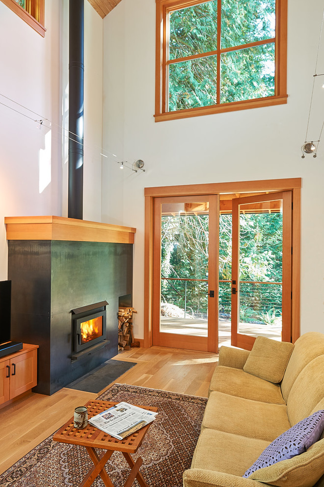 This is an example of a transitional open concept family room in Seattle with a metal fireplace surround.
