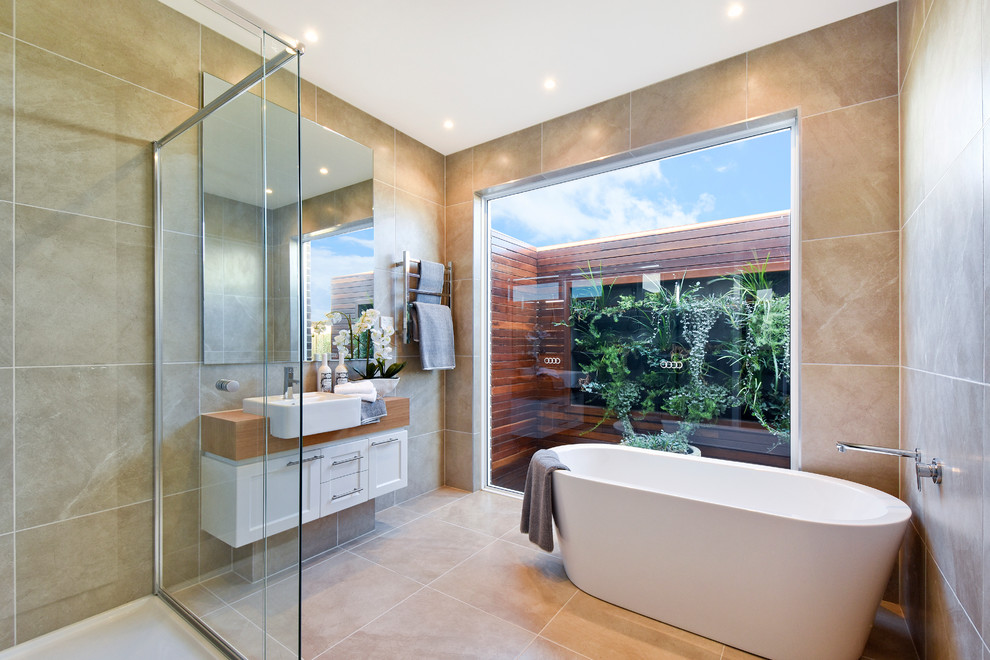 Contemporary master bathroom in Melbourne with shaker cabinets, white cabinets, a freestanding tub, beige tile and wood benchtops.