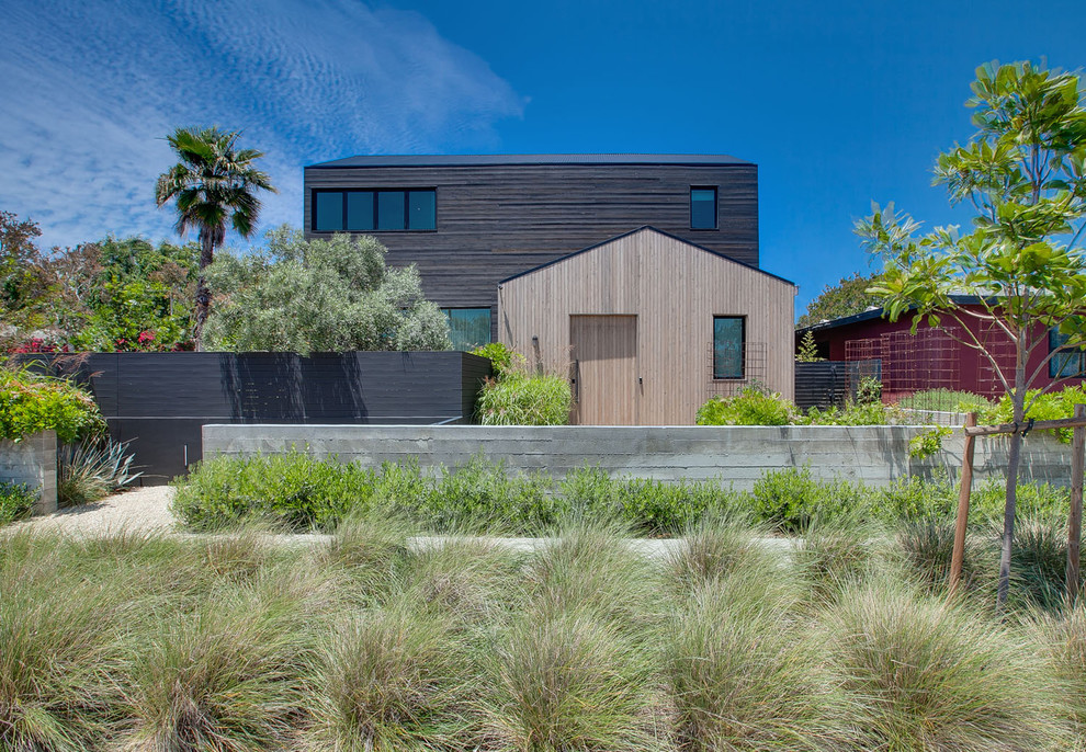 This is an example of a contemporary two-storey brown house exterior in Los Angeles with a gable roof.