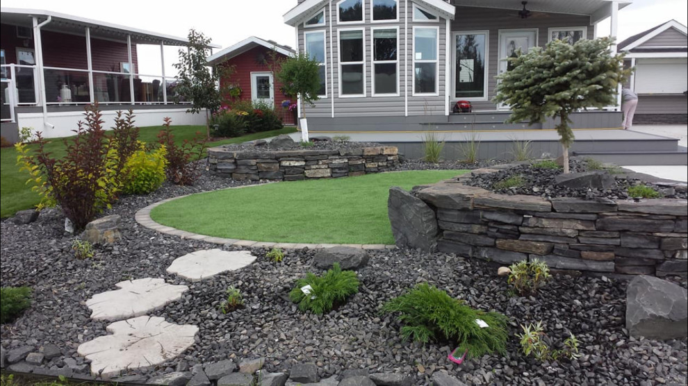 Inspiration for a mid-sized rustic full sun backyard stone landscaping in Edmonton for summer.