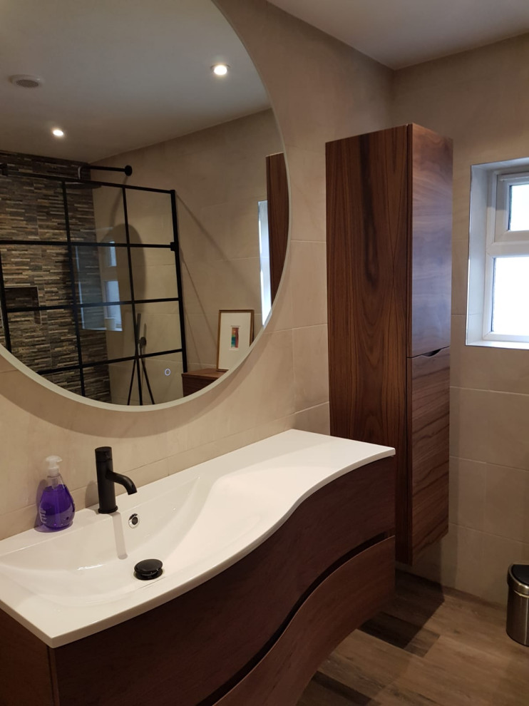 Medium sized contemporary ensuite bathroom in Oxfordshire with flat-panel cabinets, dark wood cabinets, a walk-in shower, beige tiles, porcelain tiles, beige walls, porcelain flooring, a wall-mounted sink, solid surface worktops, brown floors, an open shower, white worktops, a wall niche, a single sink and a floating vanity unit.