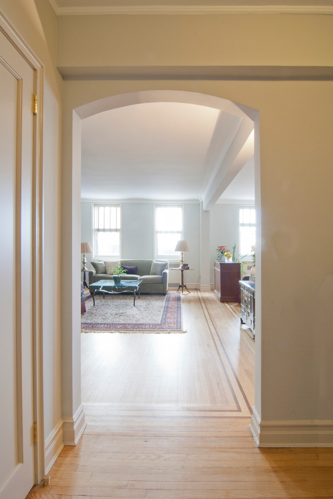 Design ideas for a small traditional hallway in New York with light hardwood floors, beige floor and grey walls.