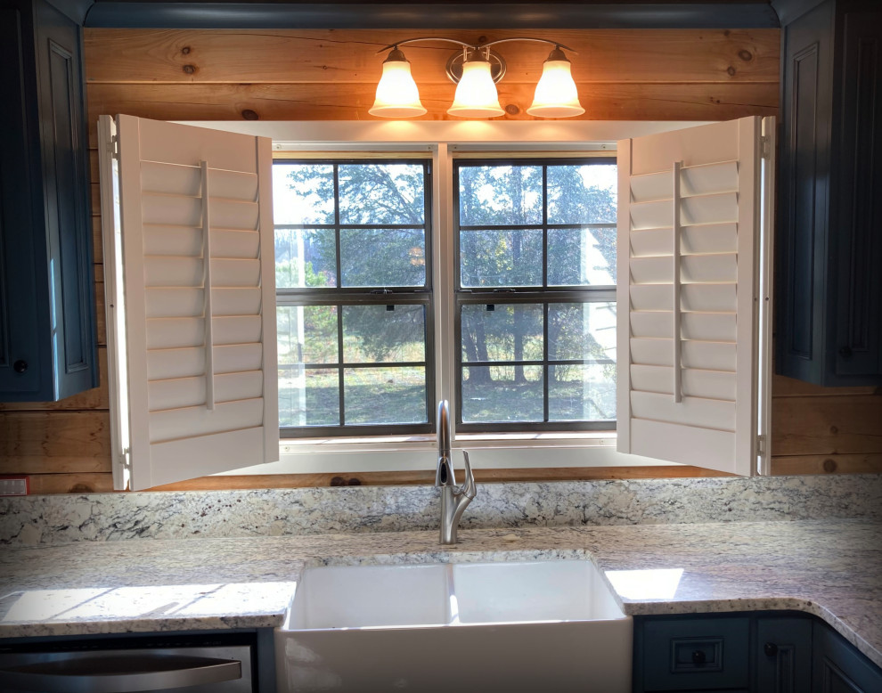 This is an example of a mid-sized country u-shaped kitchen in Other with a farmhouse sink, beaded inset cabinets, blue cabinets, granite benchtops, stainless steel appliances, laminate floors, with island, grey floor, multi-coloured benchtop and wood.