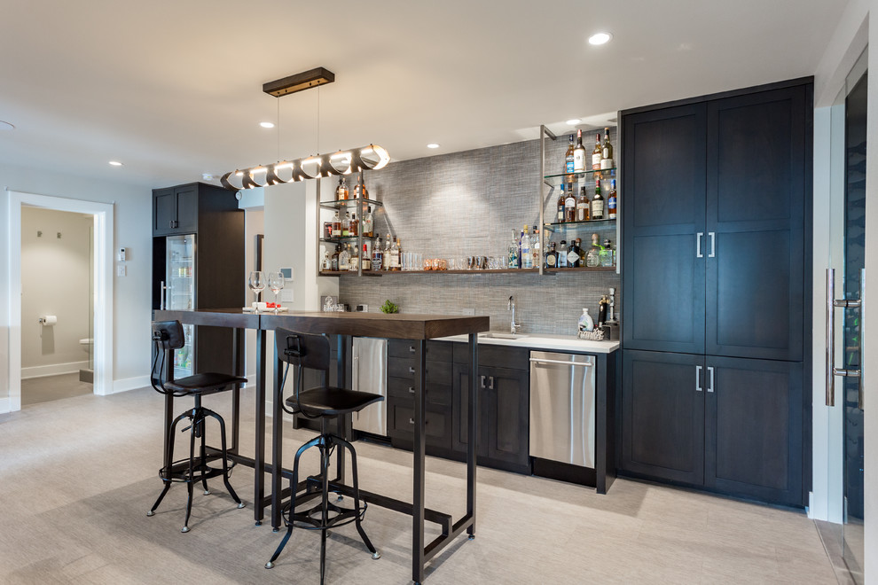 Inspiration for a contemporary single-wall wet bar in Portland with an undermount sink, shaker cabinets, black cabinets, grey splashback, grey floor and white benchtop.