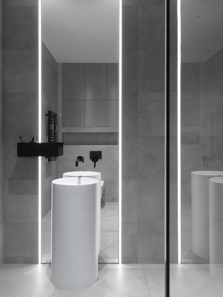 Inspiration for a medium sized contemporary cloakroom in Moscow with a wall mounted toilet, grey tiles, porcelain tiles, grey walls, porcelain flooring, an integrated sink, grey floors, feature lighting and a drop ceiling.